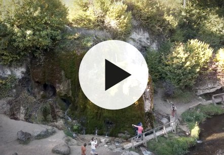 Aerial view of the growing Dreimühlen waterfall with video play button in the foreground., © Touristik GmbH Gerolsteiner Land Aerial view of the growing Dreimühlen waterfall with video play button in the foreground.
