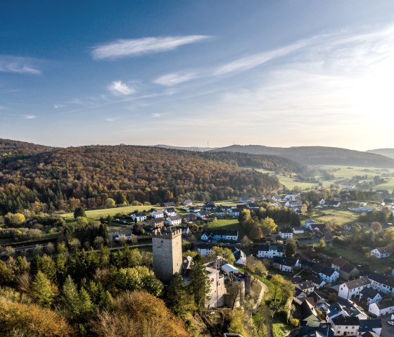 Aerial view of Kerpen in the Eifel. A castle towers over the village, surrounded by autumnal forests and fields under a blue sky., © Eifel Tourismus GmbH, Dominik Ketz Aerial view of Kerpen in the Eifel. A castle towers over the village, surrounded by autumnal forests and fields under a blue sky., © Eifel Tourismus GmbH, Dominik Ketz