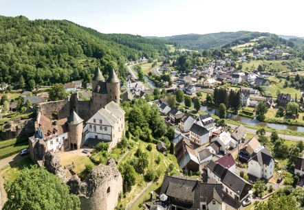 Blick von oben auf Mürlenbach mit seine Bertradaburg.
, © Eifel Tourismus GmbH, Dominik Ketz Blick von oben auf das Dorf Mürlenbach, durch das quer der Fluss Kyll fließt und auf einer Anhöhe trohnt die historische Bertradaburg.