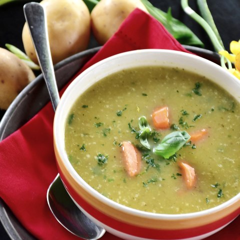 Appetitlich ngerichtete Kartoffelsuppe.
, © pixabay Eine Schale mit Kartoffelsuppe auf einem Unterteller mit Löffel und garniert mit Petersilie, Basilikum und Kartottenstücken. Daneben liegen Kartoffel und Blumen.