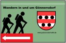Sign with two hikers, the Gönnersdorf coat of arms and the website www.goennersdorf-eifel.de. Text: "Hiking in and around Gönnersdorf"., © Touristik GmbH Gerolsteiner Land Sign with two hikers, the Gönnersdorf coat of arms and the website www.goennersdorf-eifel.de. Text: "Hiking in and around Gönnersdorf"., © Touristik GmbH Gerolsteiner Land