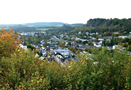 Uitzicht over Gerolstein met talrijke gebouwen en dolomietrotsen.
, © Marion Schäfer, escape from reality Uitzicht over de stad Gerolstein met talrijke gebouwen en dolomietrotsen aan de rechterkant. Bomen en struiken op de voorgrond.