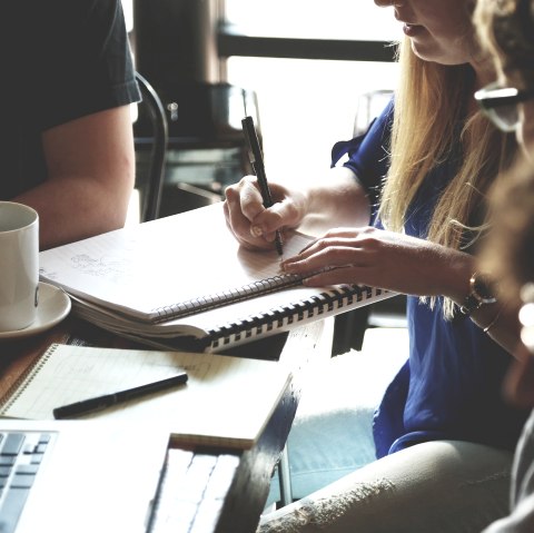 Gathering
, © Pixabay Several people are sitting together at a table. A woman is writing something on a pad.