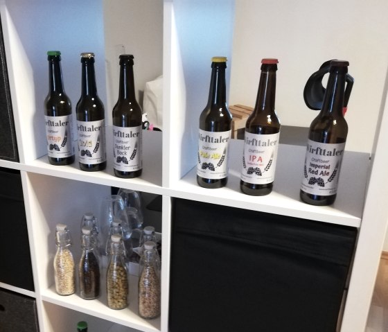 Shelf with several varieties of craft beer from the ‘Wirfttaler’ brand.
, © Touristik GmbH Gerolsteiner Land A white shelf with several compartments containing beer bottles of different varieties from the ‘Wirfttaler’ brand.