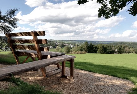 XXL bank Kerschenbach
, © Touristik GmbH Gerolsteiner Land, Nadja Blum Een oversized bank staat aan de rand van een bos voor een grote weide en kan worden beklommen via een helling.