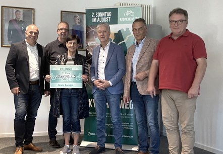 Preisverleihung Radaktionstag Grenzenlos Kyllradweg, v.l. Herr Hau (Westenergie), Herr Schmitz (Bürgermeister Stadtkyll), Frau Bresgen (Gewinnerin), Herr Wirtz (Bürgermeister Büllingen), Herr Westerburg (Bürgermeister Hellenthal), Herr Weicker (Bürgermeister Hallschlag), © Touristik GmbH Gerolsteiner Land Sechs Personen lächeln in die Kamera. Eine Frau hält einen großen Gutschein über 500 € in dne Händen.