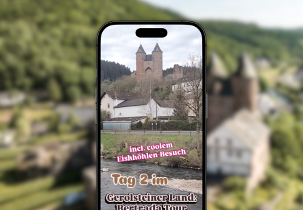 Reel Bertradatour, © Touristik GmbH Gerolsteiner Land Vor dem verschwommenen Hintergrund ist ein Handy, welches auf Instagram das Reel zum Wanderweg Bertradatour zeigt.