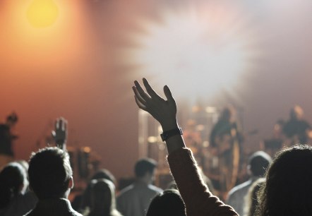 Live-Konzert , © pixabay Mehrere Arme und Köpfe mit Blick zu einer Bühne bei einem Live-Konzert