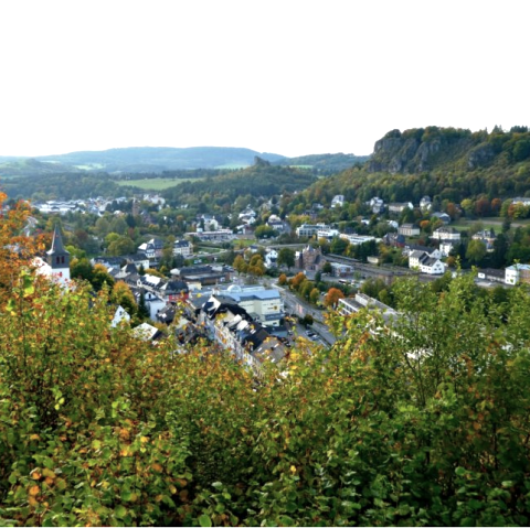 Blick über Gerolstein mit zahlreichen Gebäuden und Dolomitfelsen.
, © Marion Schäfer, escape from reality Blick über die Stadt Gerolstein mit zahlreichen Gebäuden und Dolomitfelsen an der rechten Seite. Bäume und Sträucher im Vordergrund.