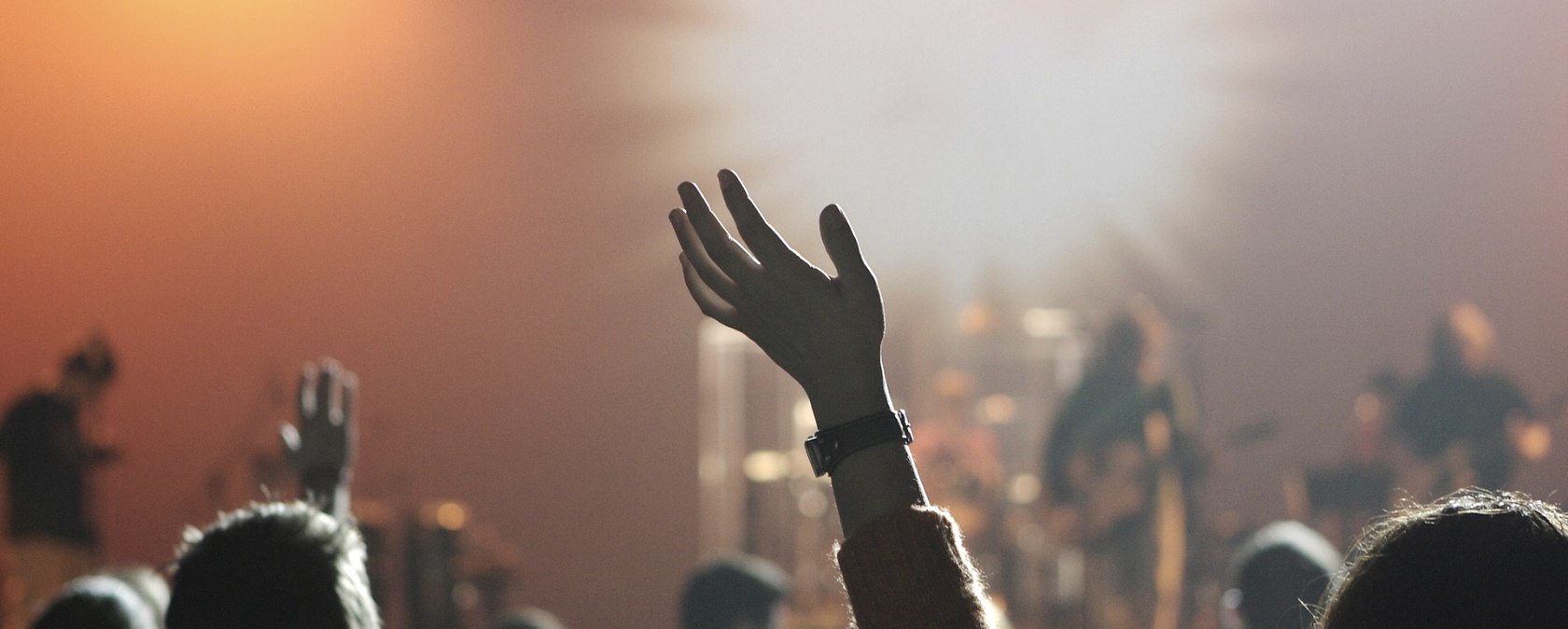 live concert, © Pixabay Several arms and heads looking towards a stage at a live concert