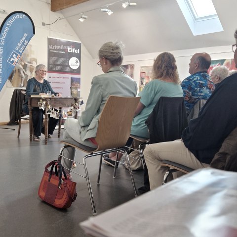 Lesung mit Krimi-Autorin Andrea Revers, © Touristik GmbH Gerolsteiner Land, Esther Erharter Zahlreiche Personen sitzen in Reihen hintereinander mit Blick zur Krimi-Autorin Andrea Revers.
