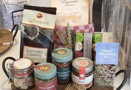 Delikatessen von Casa Zauberhaft, © Sabrina Schlederer Rundes Servierbrett aus Holz mit vielen Gläsern und Tüten voller Delikatessen darin.