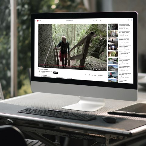 Wandervideos auf Youtube
, © Touristik GmbH Gerolsteiner Land Ein Computerbildschrim auf einem Tisch, worauf ein Youtubevideo über einen Wanderweg abgespielt wird.