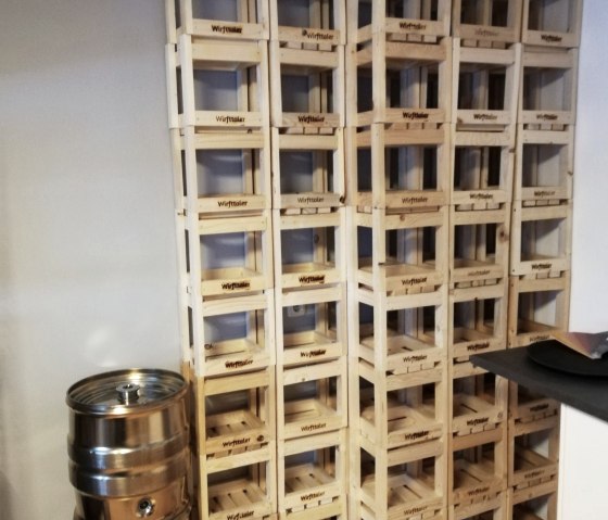 Tall stacks of wooden transport crates from the ‘Wirfttaler’ brand.
, © Touristik GmbH Gerolsteiner Land Numerous wooden crates labelled ‘Wirfttaler’ are stacked up to the ceiling.
