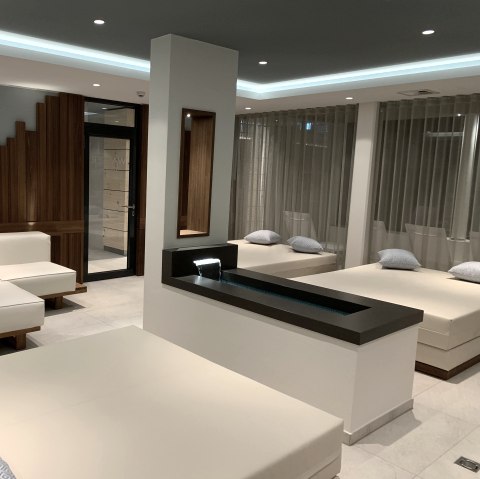 Neue Wasserlounge im Seehotel am Stausee, © Seehotel am Stausee Mehrere stirile Liegen und Sofas in einem Raum verteilt. In der Mitte ein kleines Wasserbecken.