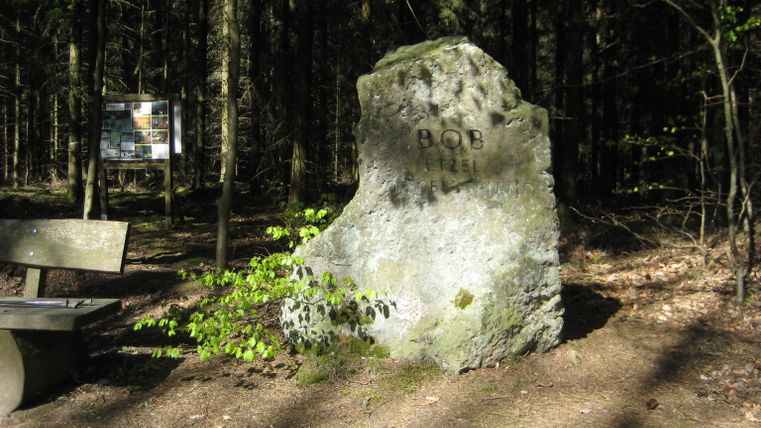 Gedenkstein im Wald mit der Aufschrift 'BOB ETZEL'.