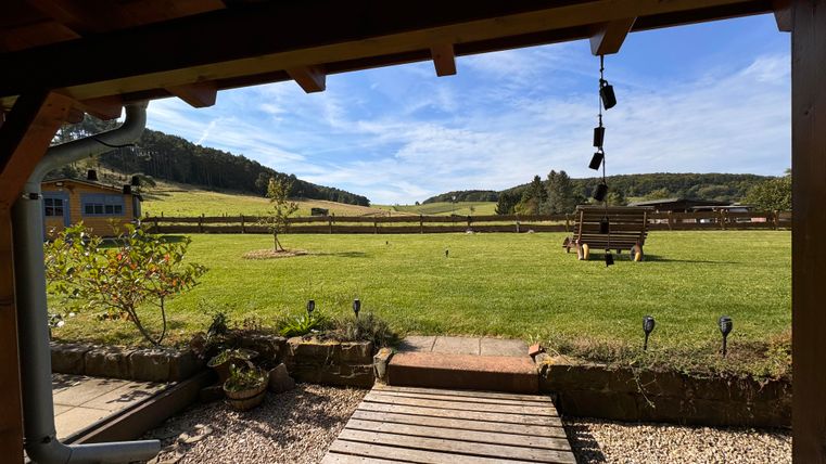 Über eine große doppelflügelige Terrassentür gelangen Sie vom Wohn-/ Essbereich auf die überdachte Panoramaterrasse. Außen vor den Terrassentüren sind in den Sommermonaten Fliegengittertüren montiert. Genießen Sie den großartigen Ausblick in das Naturschutzgebiet schon beim Frühstück!