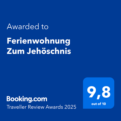 Een onderscheidingsbord voor het vakantiehuis "Zum Jehöschnis". Beoordeeld met 9,8 van de 10 punten voor de Traveller Review Awards 2025.