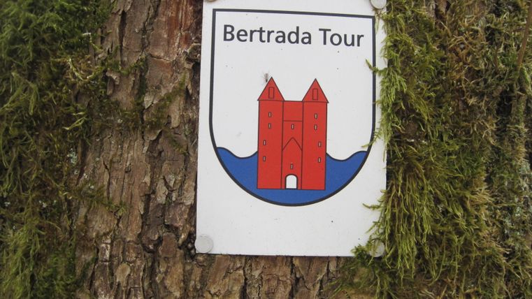 Bertrada Tour bord op een boomstam met mos.