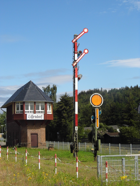 Historisches Stellwerk in Lissendorf mit Signalmasten und blauen Himmel im Hintergrund.