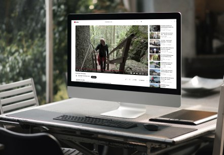 Ein Computerbildschrim auf einem Tisch, worauf ein Youtubevideo &uuml;ber einen Wanderweg abgespielt wird.