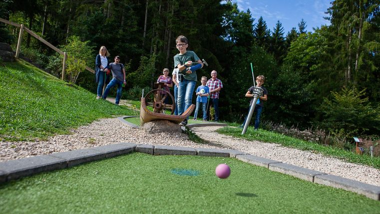 Mehrere Kinder, die Minigolf spielen