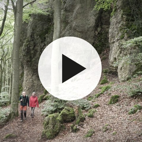 Hikers on the Gerolstein rock trail with video play button in the foreground.