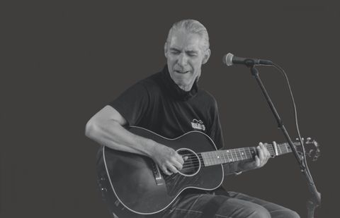 Ralph Brauner spielt auf seiner Gitarre. Bild in schwarz-weiß