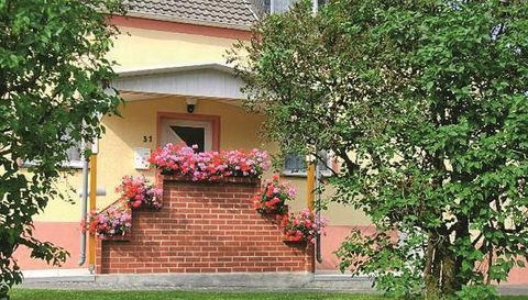 Ein gemütliches Haus mit einem blühenden Vorgarten. Bunte Blumen schmücken den Eingangsbereich.