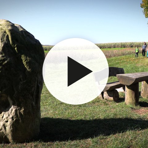 Wanderer im Wandergebiet Hirschbergsattel bei Birgel mit Video-Playbutton im Vordergrund.