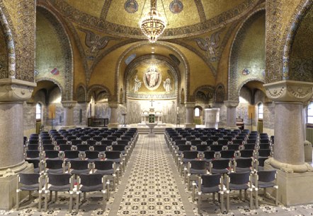 De foto toont het interieur van de Kerk van de Verlosser met zicht op het plafond en het altaar. Het plafond is versierd met gouden moza&iuml;eken, engelen en een grote kroonluchter. Ramen laten licht binnen in het prachtige kerkinterieur. Talloze stoelen vormen rijen zitplaatsen voor bezoekers.