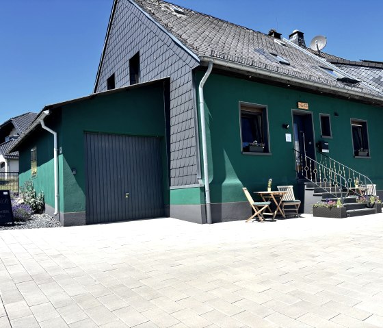 Außenansicht der Pension mit Parkplatz