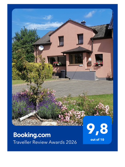 Auszeichnung von booking.com für die Ferienwohnung am Wasserfall mit Bild der Unterkunft von außen.