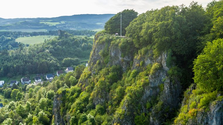 Blick auf das Munterley Plateau mit bewaldeten Klippen und Häusern im Tal.