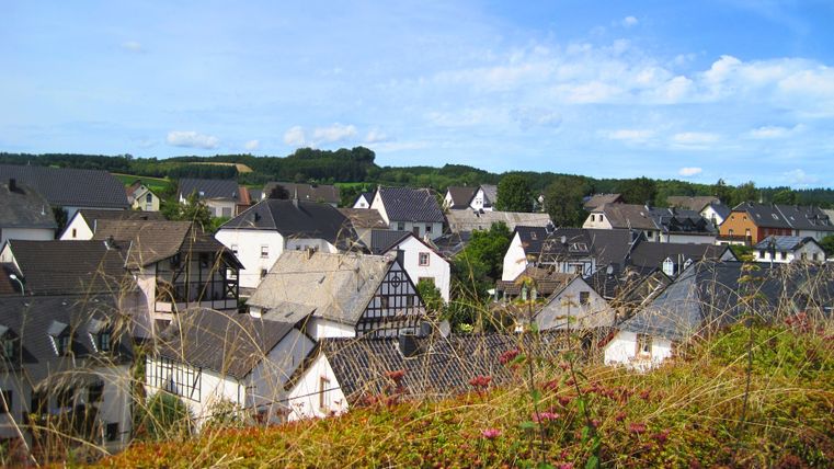 Blick auf Kerpen mit Fachwerkhäusern und grüner Landschaft im Hintergrund.