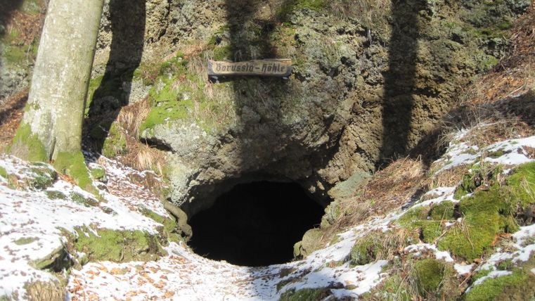 Eingang der Borussia-Höhle in Hohenfels-Essingen mit Moos und Schnee bedeckt.