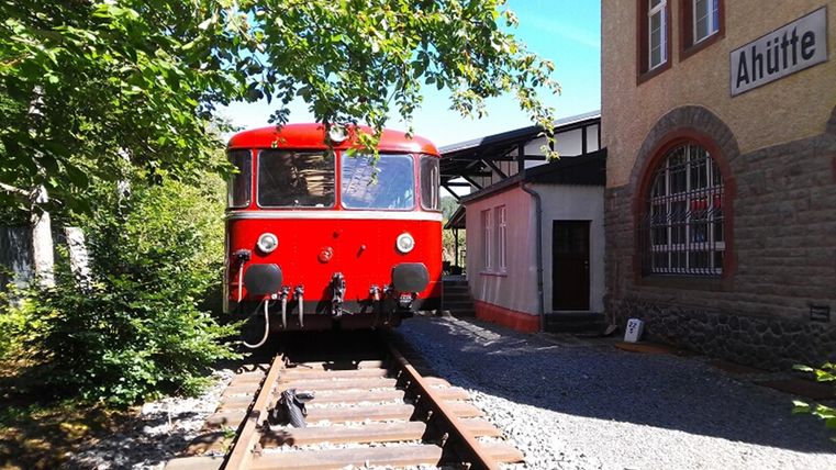 Vue extérieure du bâtiment du musée. Une ancienne locomotive à vapeur rouge est garée devant.