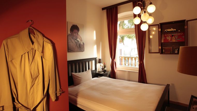 Une chambre confortable avec un lit et une armoire suspendue. Il y a une belle vue à travers la fenêtre et des éléments décoratifs sur les murs.