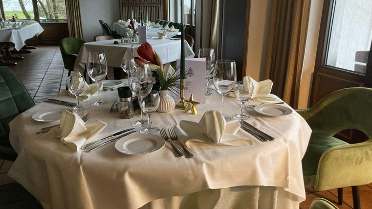 Een elegant gedekte tafel in een restaurant. De tafel is versierd met glazen decoraties en servetten.