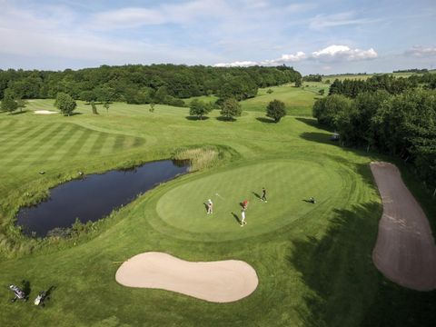 Blick von oben auf Golfplatz mit Bunker, Teich und Green fee
