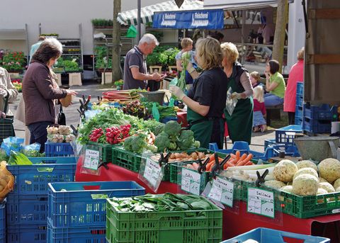 Animation colorée du marché un jour d'été avec des acheteurs et des commerçants à un stand de légumes