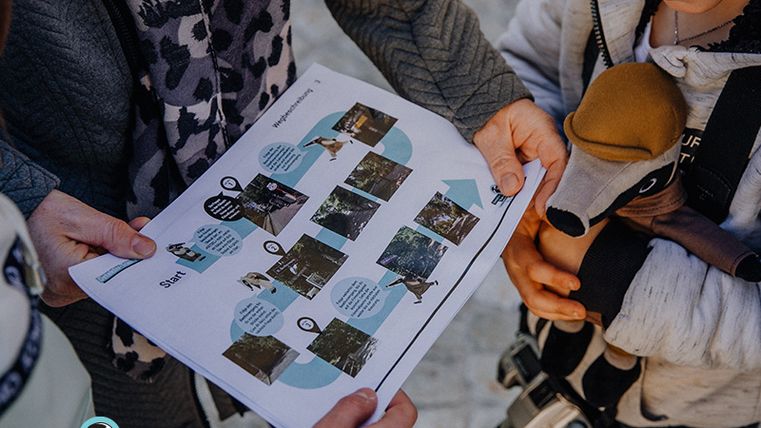 Zwei Personen betrachten eine Schatzkarte für eine Detektiv-Trails-Familienaktivität.