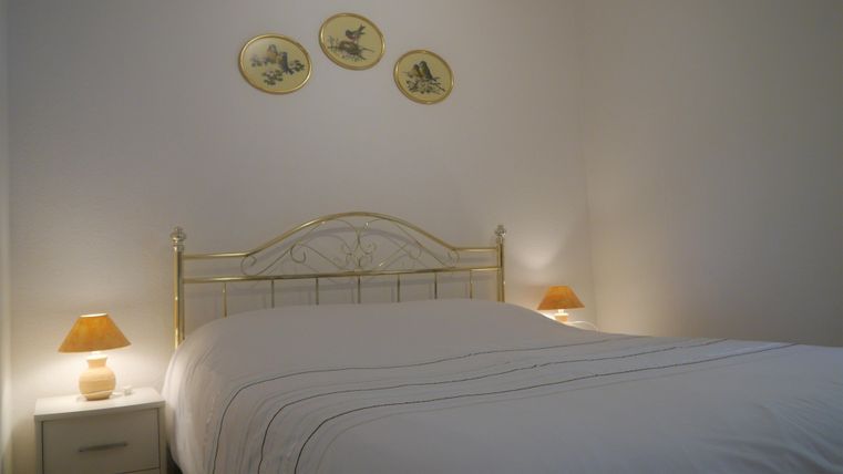 Ein gemütliches Schlafzimmer mit einem großen Bett und sanften Beleuchtung. An der Wand hängen dekorative Teller.