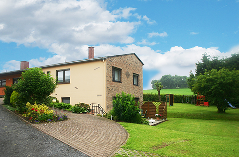 Das Bild zeigt ein charmantes Einfamilienhaus in einer malerischen Umgebung, das die Ruhe und den Frieden einer ländlichen Szene einfängt.