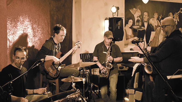 Un groupe de jazz joue dans un club confortable. Les musiciens apprécient l'atmosphère et prennent soin de leurs instruments.