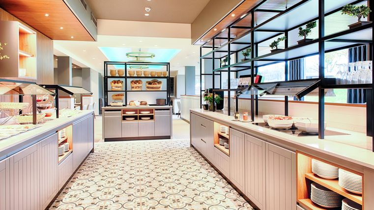 Ein modernes Buffet mit eleganten Möbeln und einer hellen, einladenden Atmosphäre. Es gibt verschiedene Speisen und eine stilvolle Präsentation.