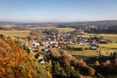 Ein Ort mit einigen Wohngebäuden inmitten einer herbstlichen Landschaft.