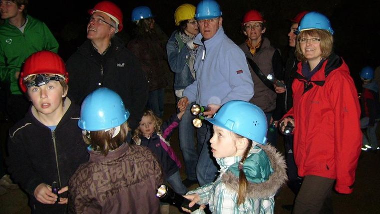 eine Gruppe Kinder mit Helm in den Eishöhlen