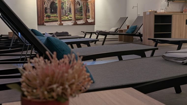 Mehrere Liegebänke stehen nebeneinander in einem Wellnessraum.