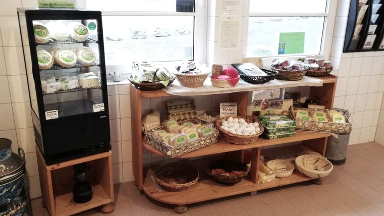 Verkaufsregale auf dem Gröner Hof mit zahlreichen regionalen Produkten aus Eigenproduktion wie Käse, Wurstwaren und Eiern.